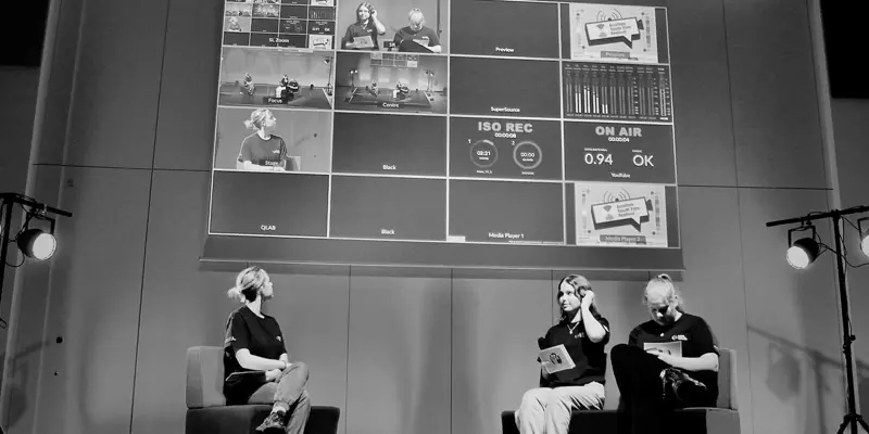 3 people on stage and a large projection of a storyboard.