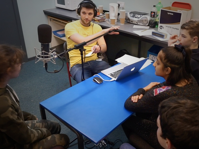 a group of school children record audio